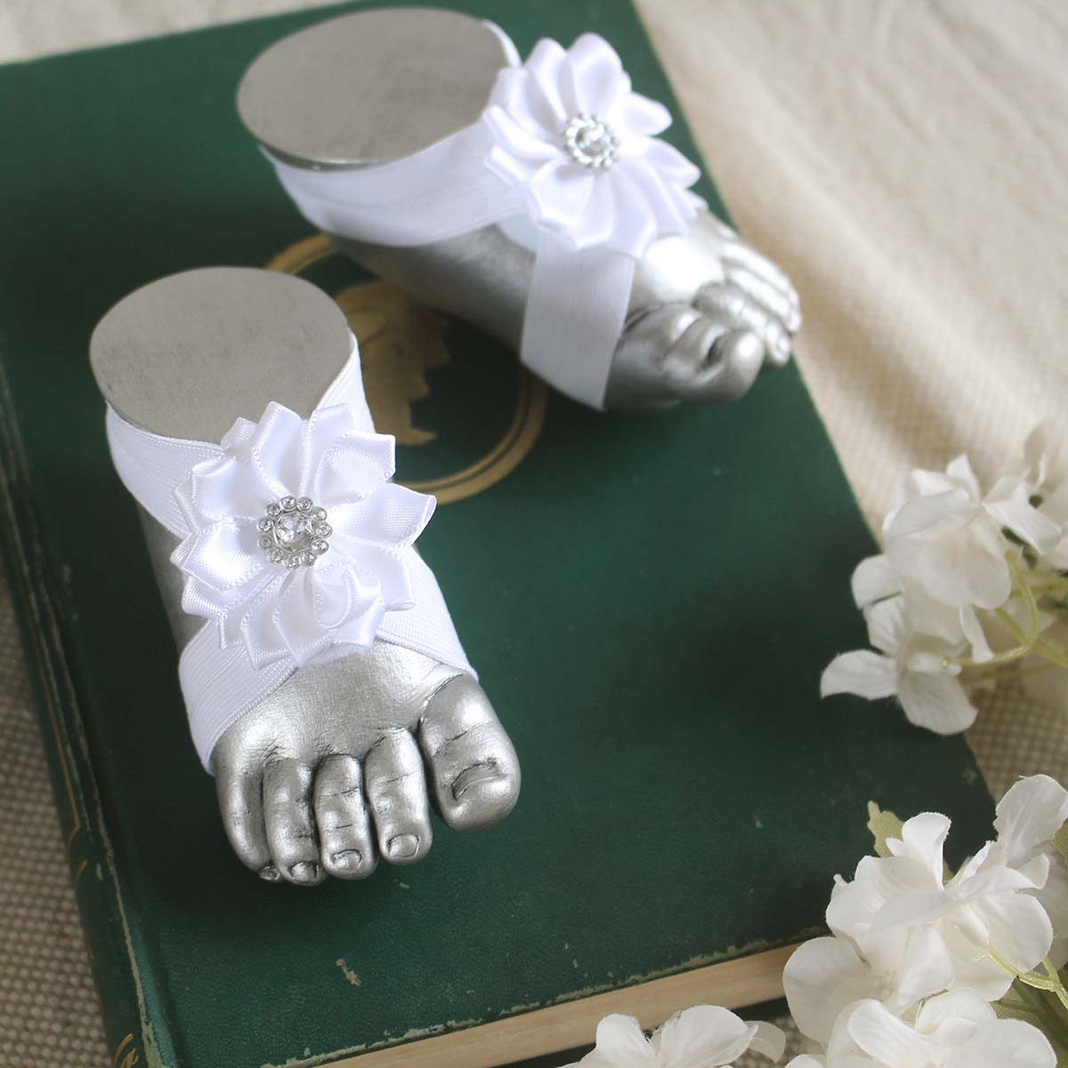 Pies descalzos con flor de pétalos y detalles plateado